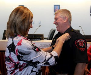 Board President Helen Warwick pins the chief's badge on new MISD Police Chief, Joe Arledge.